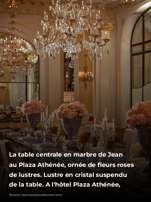 La table centrale en marbre de Jean Imbert au Plaza Athénée, ornée de fleurs roses et de lustres.  Lustre en cristal suspendu au-dessus de la table. A l'hôtel Plaza Athénée, Paris