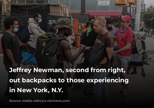 Jeffrey Newman, second from right, hands out backpacks to those experiencing homelessness in New York, N.Y.