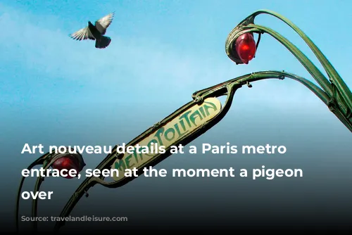 Art nouveau details at a Paris metro station entrace, seen at the moment a pigeon flies over