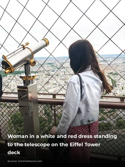 Woman in a white and red dress standing next to the telescope on the Eiffel Tower observation deck