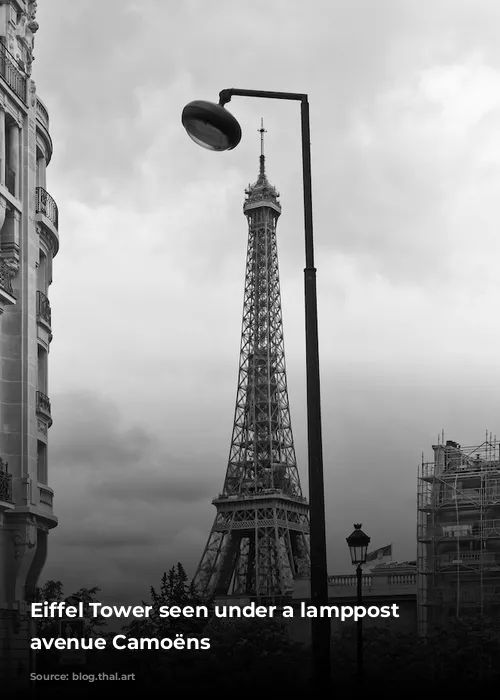 Eiffel Tower seen under a lamppost from avenue Camoëns