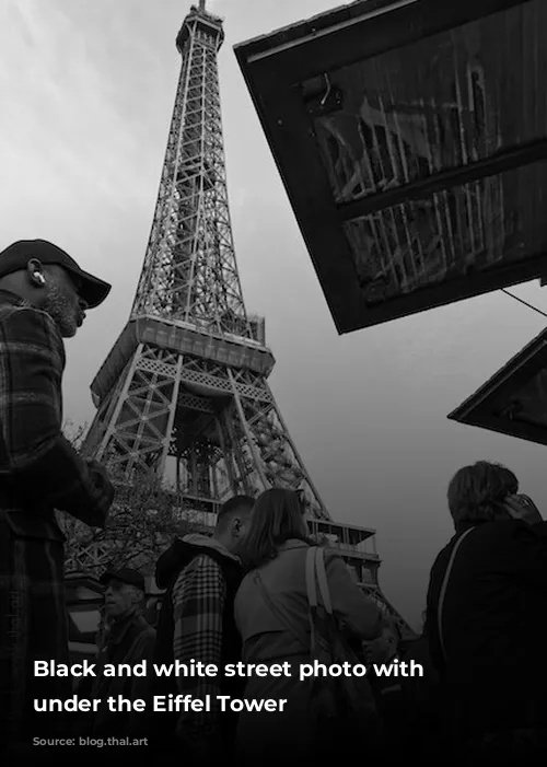 Black and white street photo with passers-by under the Eiffel Tower