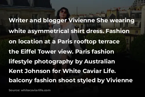 Writer and blogger Vivienne She wearing a white asymmetrical shirt dress. Fashion portraits on location at a Paris rooftop terrace with the Eiffel Tower view. Paris fashion and lifestyle photography by Australian photographer Kent Johnson for White Caviar Life. Paris balcony fashion shoot styled by Vivienne She.