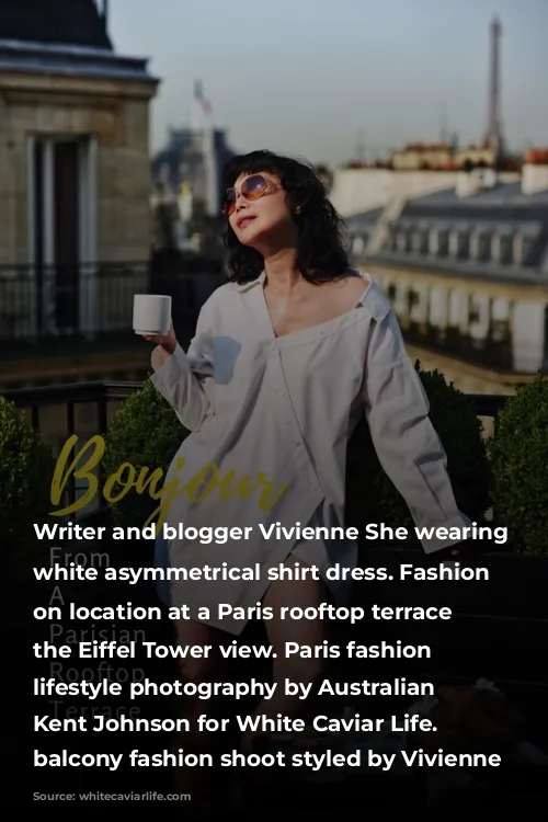 Writer and blogger Vivienne She wearing a white asymmetrical shirt dress. Fashion portraits on location at a Paris rooftop terrace with the Eiffel Tower view. Paris fashion and lifestyle photography by Australian photographer Kent Johnson for White Caviar Life. Paris balcony fashion shoot styled by Vivienne She.