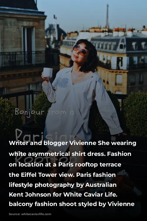 Writer and blogger Vivienne She wearing a white asymmetrical shirt dress. Fashion portraits on location at a Paris rooftop terrace with the Eiffel Tower view. Paris fashion and lifestyle photography by Australian photographer Kent Johnson for White Caviar Life. Paris balcony fashion shoot styled by Vivienne She.