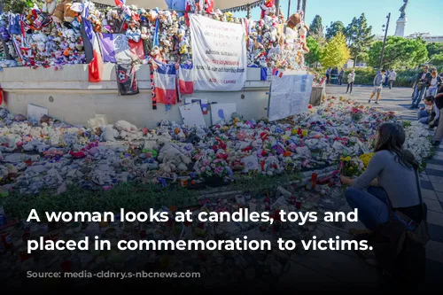 A woman looks at candles, toys and flowers placed in commemoration to victims.