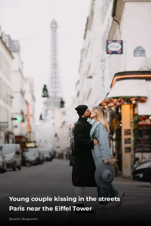 Young couple kissing in the streets of Paris near the Eiffel Tower