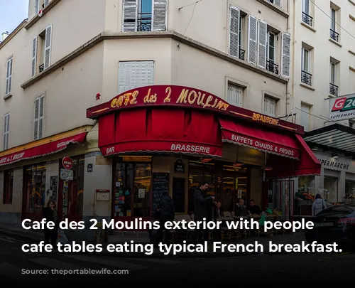 Cafe des 2 Moulins exterior with people at cafe tables eating typical French breakfast.