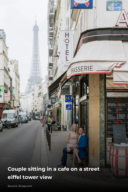 Couple sitting in a cafe on a street with eiffel tower view