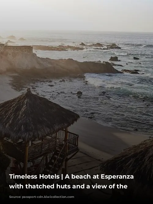 Timeless Hotels | A beach at Esperanza resort with thatched huts and a view of the ocean