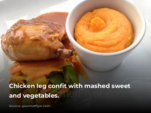 Chicken leg confit with mashed sweet potatoes and vegetables.