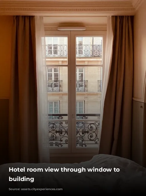 Hotel room view through window to neighboring building