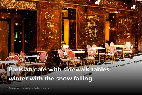 Parisian cafe with sidewalk tables in winter with the snow falling