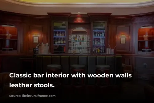 Classic bar interior with wooden walls and leather stools.