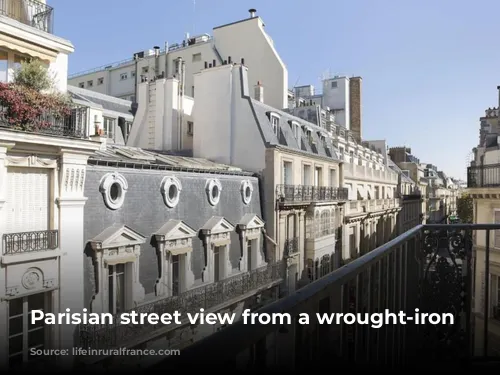 Parisian street view from a wrought-iron balcony.