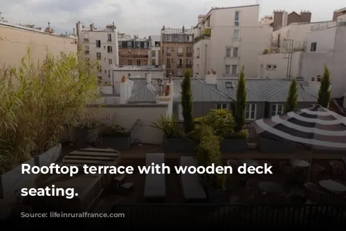 Rooftop terrace with wooden deck and seating.