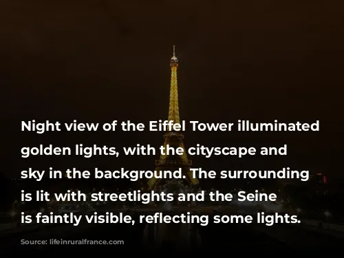 Night view of the Eiffel Tower illuminated with golden lights, with the cityscape and dark sky in the background. The surrounding area is lit with streetlights and the Seine River is faintly visible, reflecting some lights.