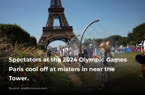 Spectators at the 2024 Olympic Games in Paris cool off at misters in near the Eiffel Tower.