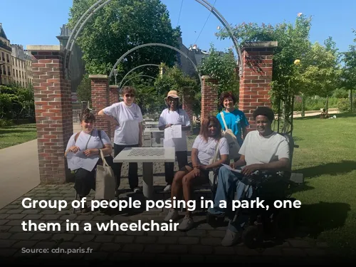 Group of people posing in a park, one of them in a wheelchair